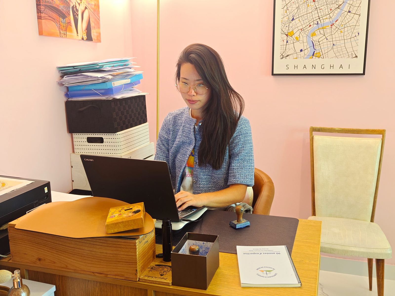 Ying Zhang Giroud à son bureau : dossiers de traduction en cours, sceau d’expert judiciaire et documents de la Compagnie d’experts de justice de Riom